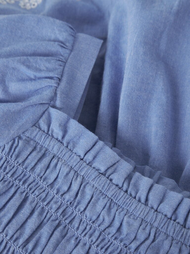 Dettaglio del corpetto a smock elasticizzato dell'abito estivo azzurro Scugnizzi 0-16 in morbido tessuto traspirante
