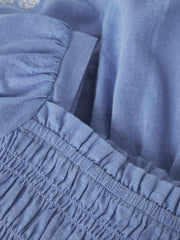 Dettaglio del corpetto a smock elasticizzato dell'abito estivo azzurro Scugnizzi 0-16 in morbido tessuto traspirante