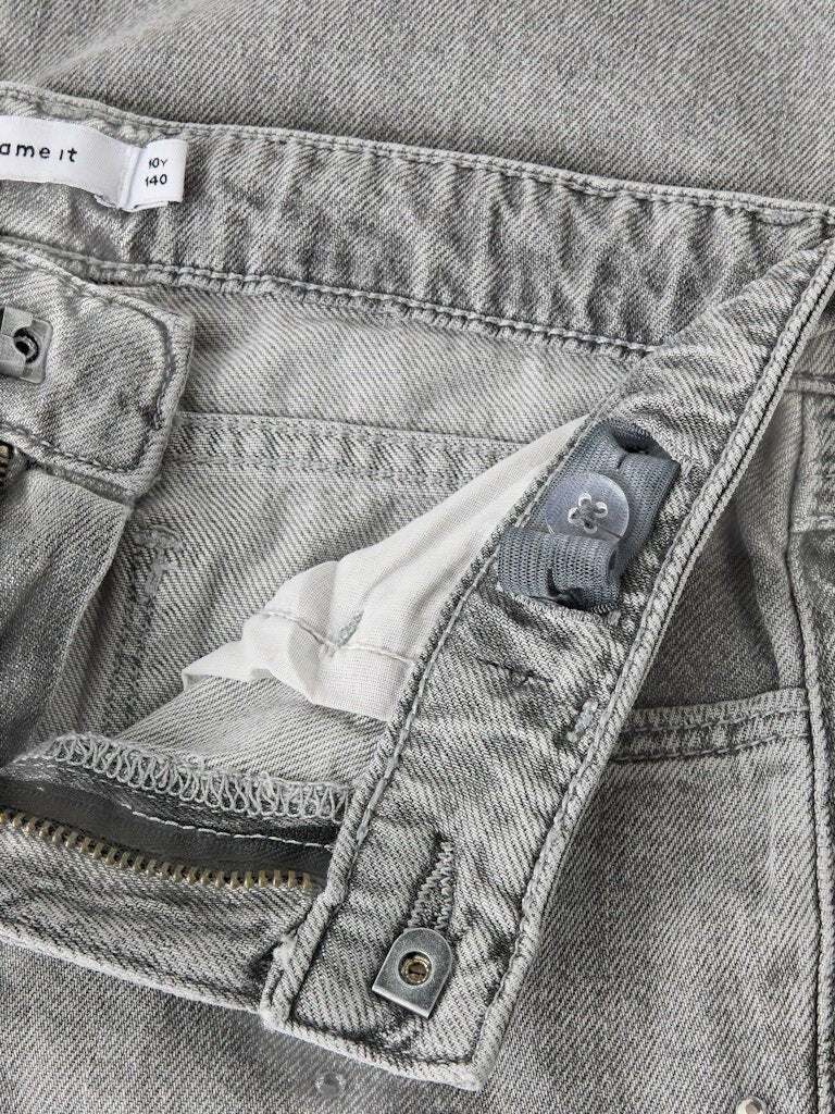Dettaglio della vita di pantaloni in denim Scugnizzi 0-16 con elastico regolabile interno e chiusura a bottone