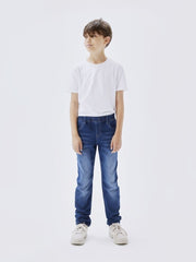 Bambino indossa jeans Scugnizzi 0-16 in denim blu con vita elasticizzata e coulisse, abbinati a t-shirt bianca