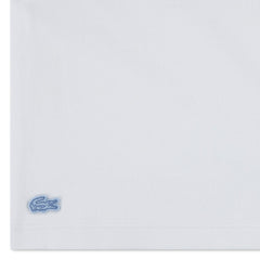 Dettaglio del logo coccodrillo ricamato su t-shirt bianca in cotone del completo Scugnizzi 0-16 Lacoste