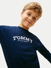 Ragazzo indossa maglia a maniche lunghe blu Tommy Hilfiger con logo bianco sul petto, proposta da Scugnizzi 0-16