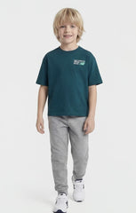 Bambino indossa maglietta verde petrolio Scugnizzi 0-16 in cotone con logo New Balance sul petto e pantaloni grigi