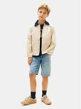 Ragazzo indossa pantaloncini in denim azzurro chiaro Scugnizzi 0-16 con giacca beige e scarpe da ginnastica