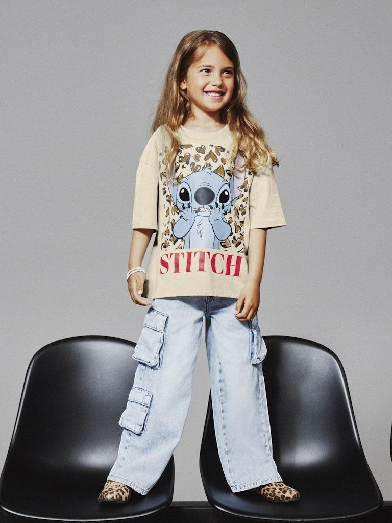 Bambina indossa pantaloni cargo in denim Scugnizzi 0-16 lavaggio chiaro con tasche laterali e t-shirt di Stitch