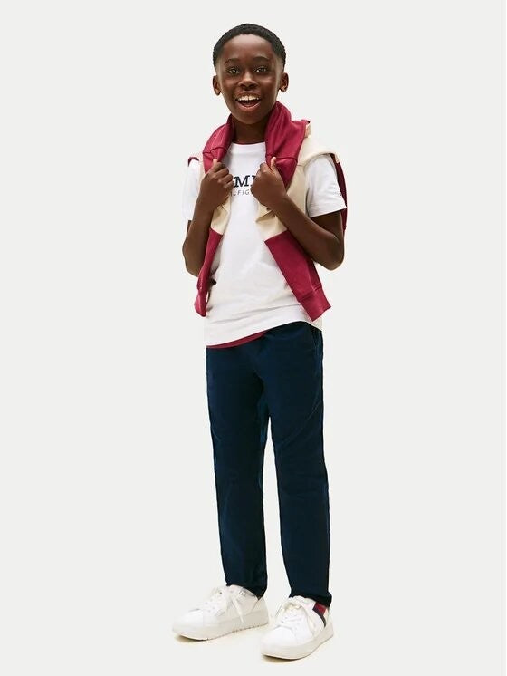 Ragazzo indossa maglietta bianca in cotone Tommy Hilfiger con logo sul petto e felpa bordeaux sulle spalle