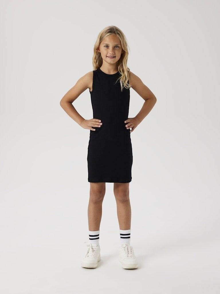 Bambina indossa un vestito nero a costine senza maniche di Scugnizzi 0-16, abbinato a sneakers bianche e calzini sportivi