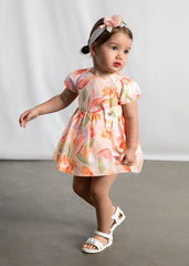 Abito estivo Scugnizzi 0-16 per bambina con stampa floreale arancione, rosa e lilla, maniche a sbuffo e fiocco decorativo.