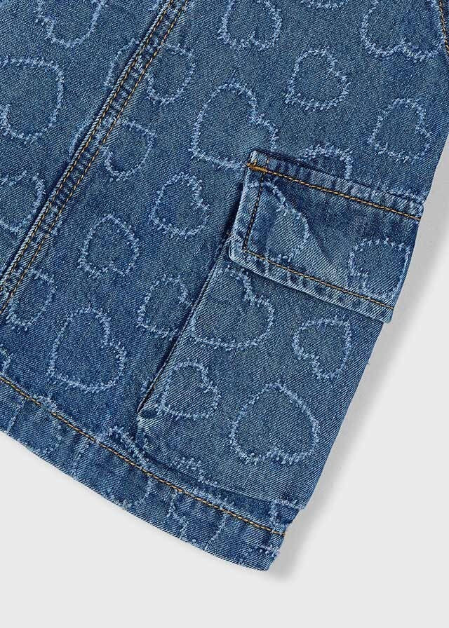 Abito salopette in denim blu per bambina Scugnizzi 0-16 con motivo a cuori all-over e tasca applicata.