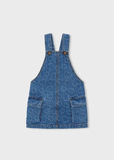 Abito salopette in denim blu per bambina Scugnizzi 0-16 con motivo a cuori all-over, tasche applicate e spalline regolabili.