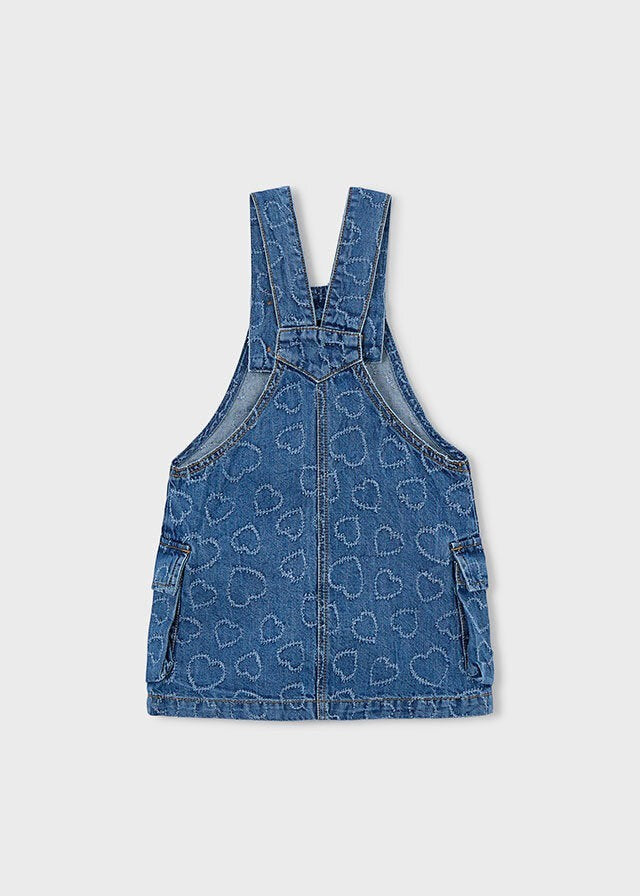 Abito salopette in denim blu per bambina Scugnizzi 0-16 con motivo a cuori all-over e tasche applicate.