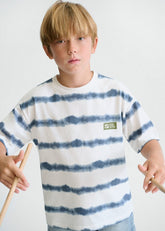 Maglietta a righe tie-dye blu e bianche in cotone per bambino Scugnizzi 0-16, con patch sul petto.