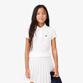 Polo bianca in cotone 100% per bambina Lacoste con colletto e logo coccodrillo verde. Stile sportivo.