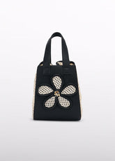 Borsa tote nera Scugnizzi 0-16 con applicazione a fiore in tessuto intrecciato color crema e pannelli laterali in paglia.