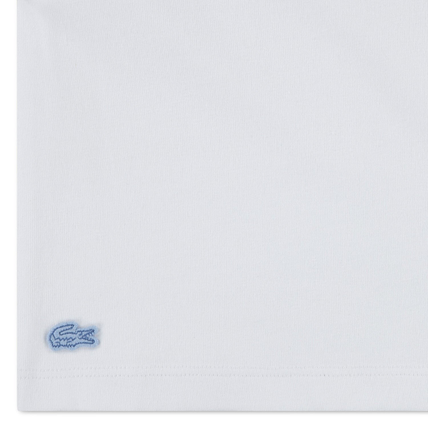 Dettaglio del logo coccodrillo ricamato su t-shirt bianca in cotone del completo Scugnizzi 0-16 Lacoste