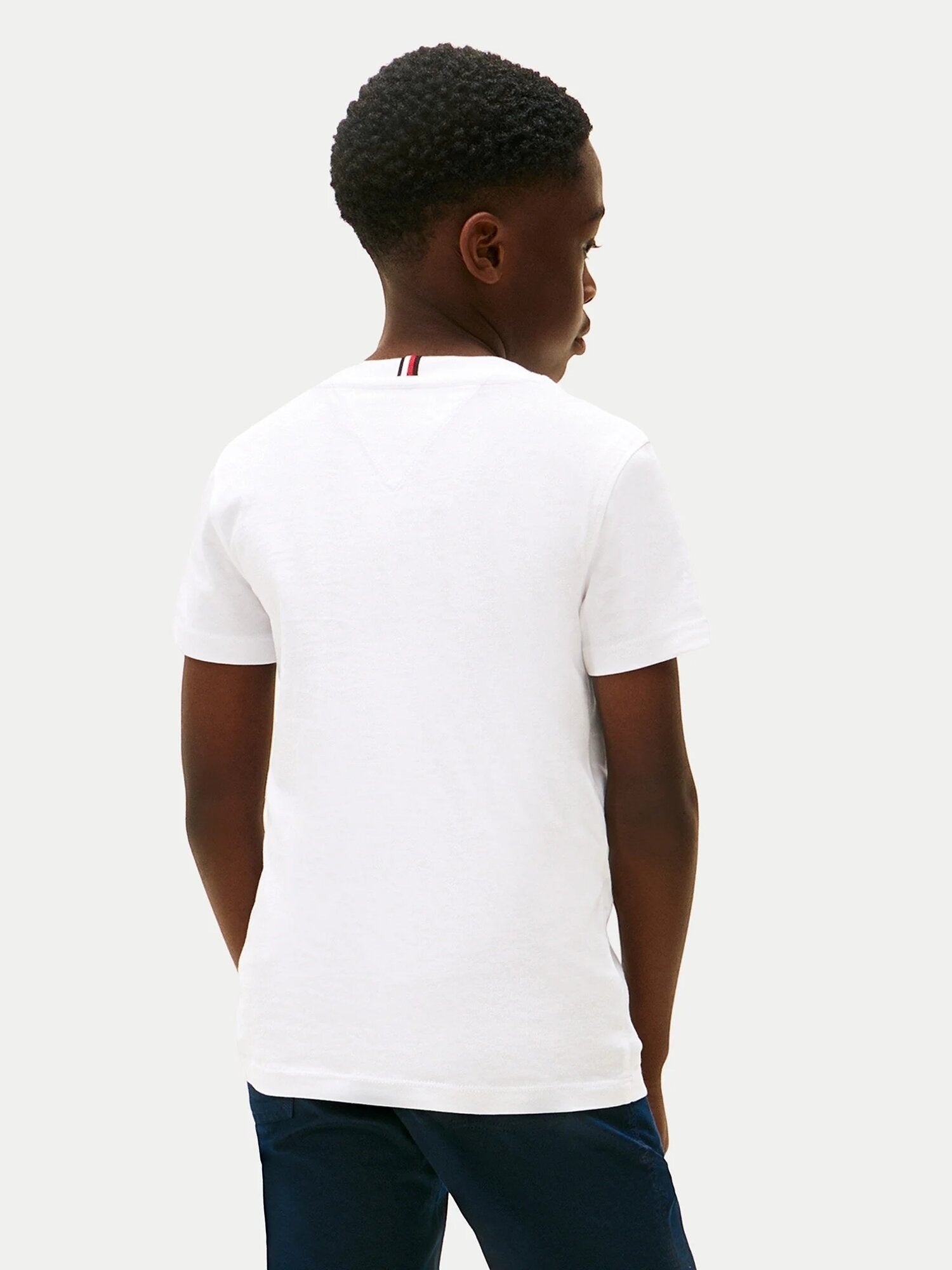 Ragazzo indossa una t-shirt bianca in cotone Scugnizzi 0-16 con dettaglio iconico sul retro del colletto