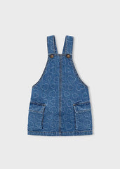 Abito salopette in denim blu per bambina Scugnizzi 0-16 con motivo a cuori all-over, tasche applicate e spalline regolabili.